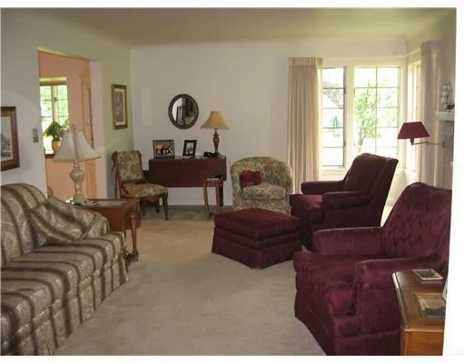 a living room with furniture a window and a lamp