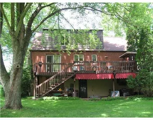 front view of house with a yard and potted plants