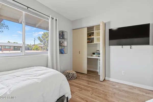 a bedroom with a bed and a flat screen tv