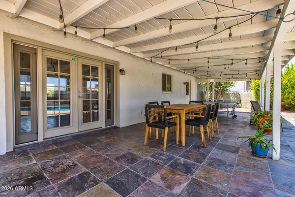 a view of a patio with a table and chairs and a barbeque