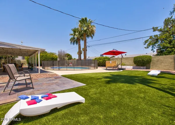a swimming pool view with a seating space and a garden view