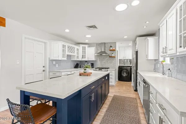 a kitchen with a sink a counter top space stainless steel appliances and cabinets