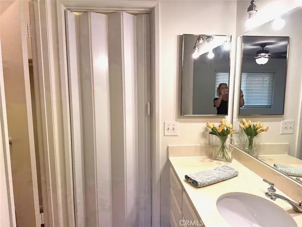 a bathroom with a granite countertop sink and a mirror