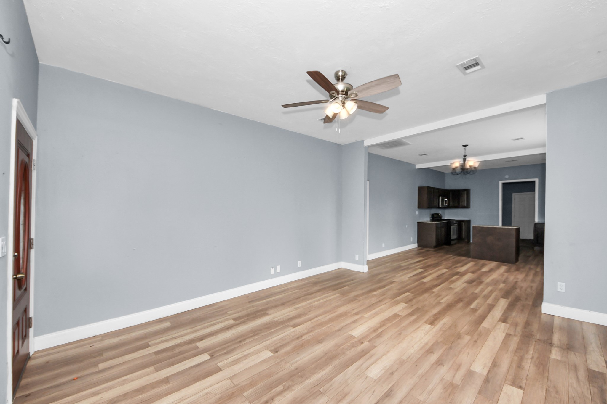 15 High Street Baytown, TX 77520 - Photo 5 of 29 a view of a big room with wooden floor and a ceiling fan