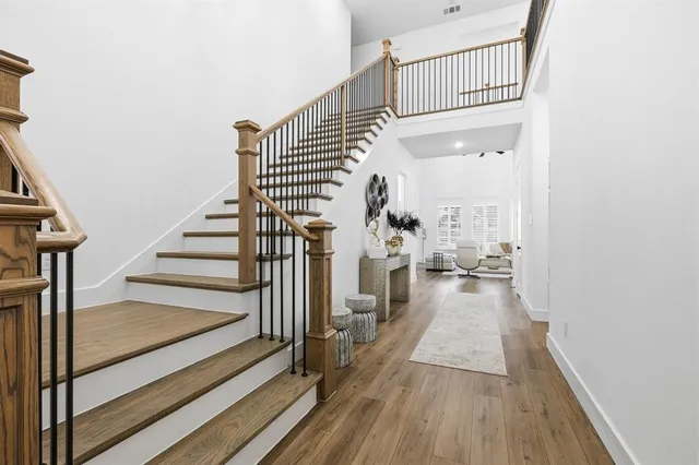 a view of a hallway with wooden floor and staircase