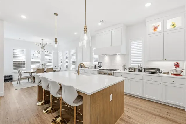 a kitchen with appliances a sink a center island and cabinets