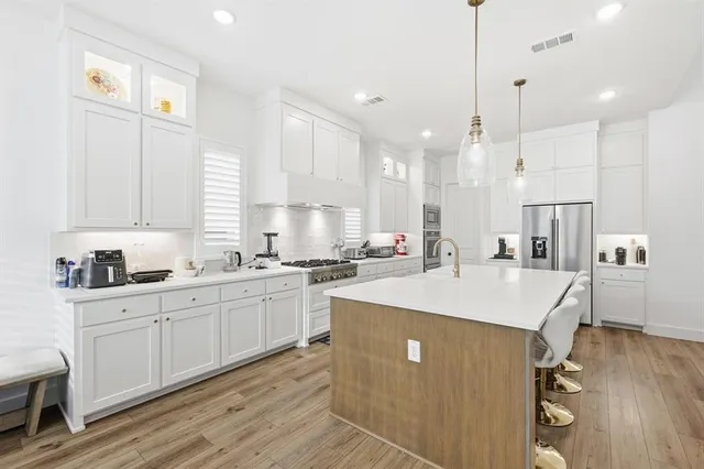 a kitchen with kitchen island a sink table and chairs