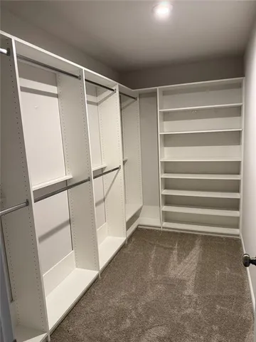 a view of walk in closet with empty racks