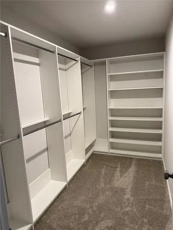 a view of walk in closet with empty racks