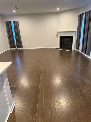 an empty room with wooden floor and fireplace