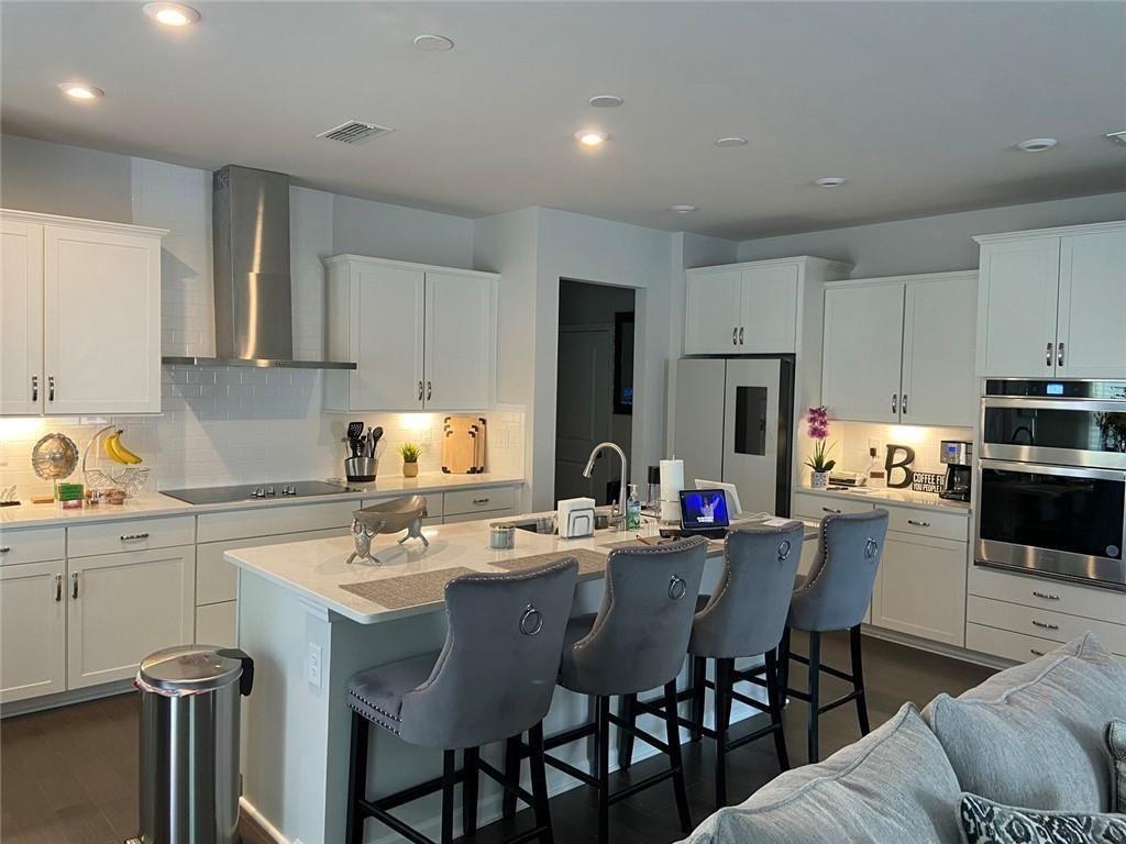 230 Mackenzie Court Covington, GA 30016 - Photo 9 of 23 a kitchen with a dining table chairs and refrigerator