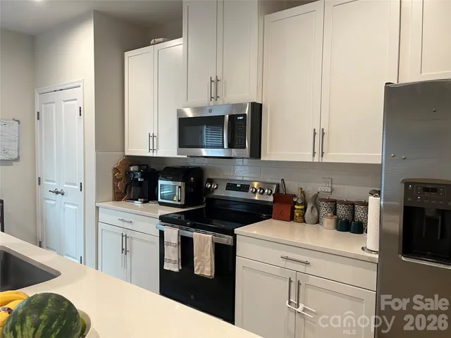 a kitchen with stainless steel appliances granite countertop a stove a sink and a refrigerator