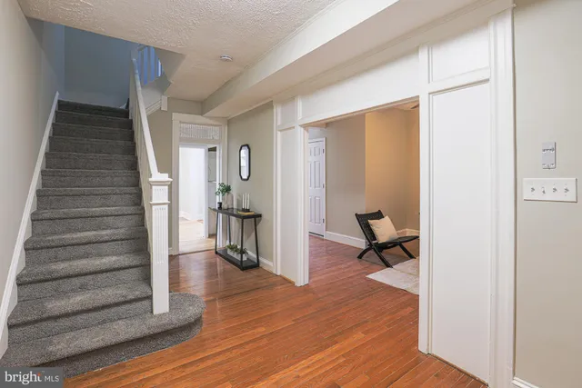a view of a hallway with wooden floor and a living room