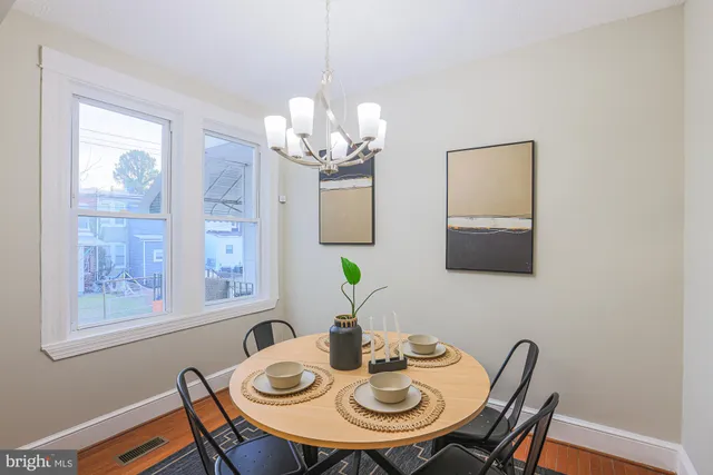 a view of a dining room with furniture a chandelier and wooden floor