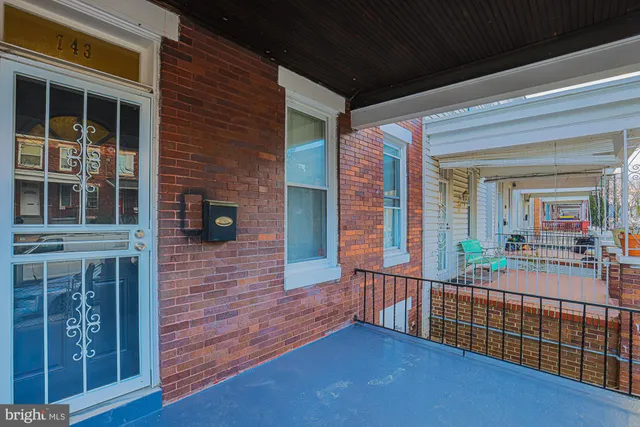 a view of a brick house with large windows and a table