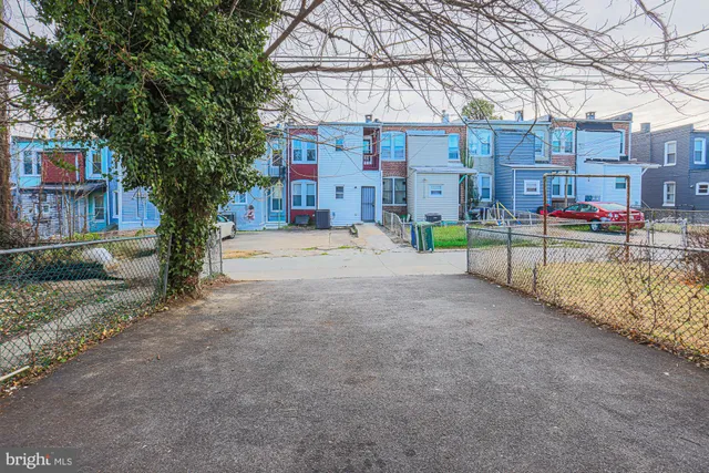 a view of a street with a small yard and large trees
