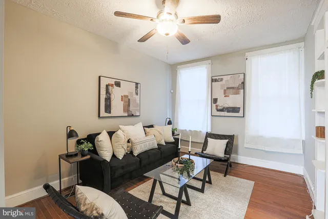 a living room with furniture and a wooden floor