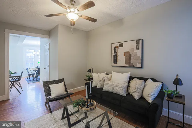 a living room with furniture and a ceiling fan