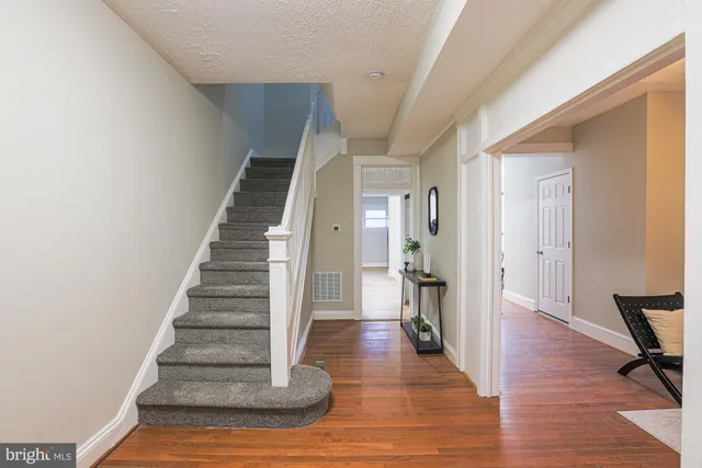 a view of a hallway with wooden floor and staircase