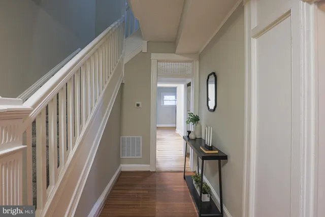 a view of a hallway with wooden floor and entryway