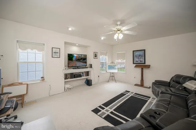 a living room with furniture a flat screen tv and a window