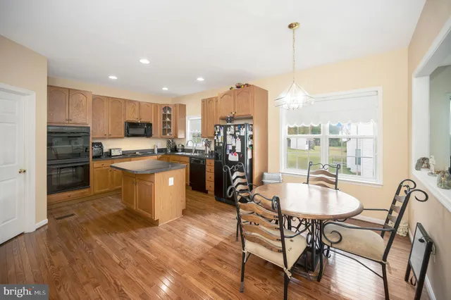 a dining room filled chandelier and wooden floor