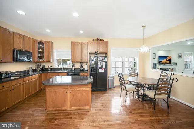 a kitchen with stainless steel appliances granite countertop a refrigerator a sink and a stove