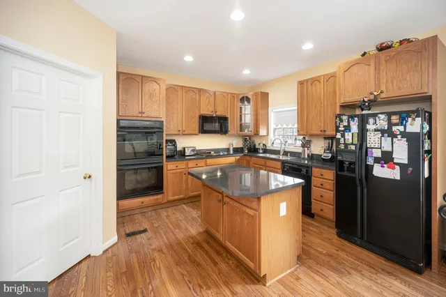a kitchen with stainless steel appliances granite countertop a sink a stove and cabinets