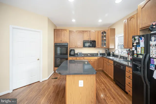 a kitchen with stainless steel appliances granite countertop a sink a stove and cabinets