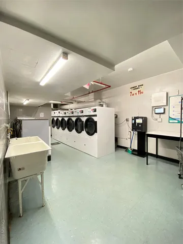 a utility room with stainless steel appliances a stove a table and chairs