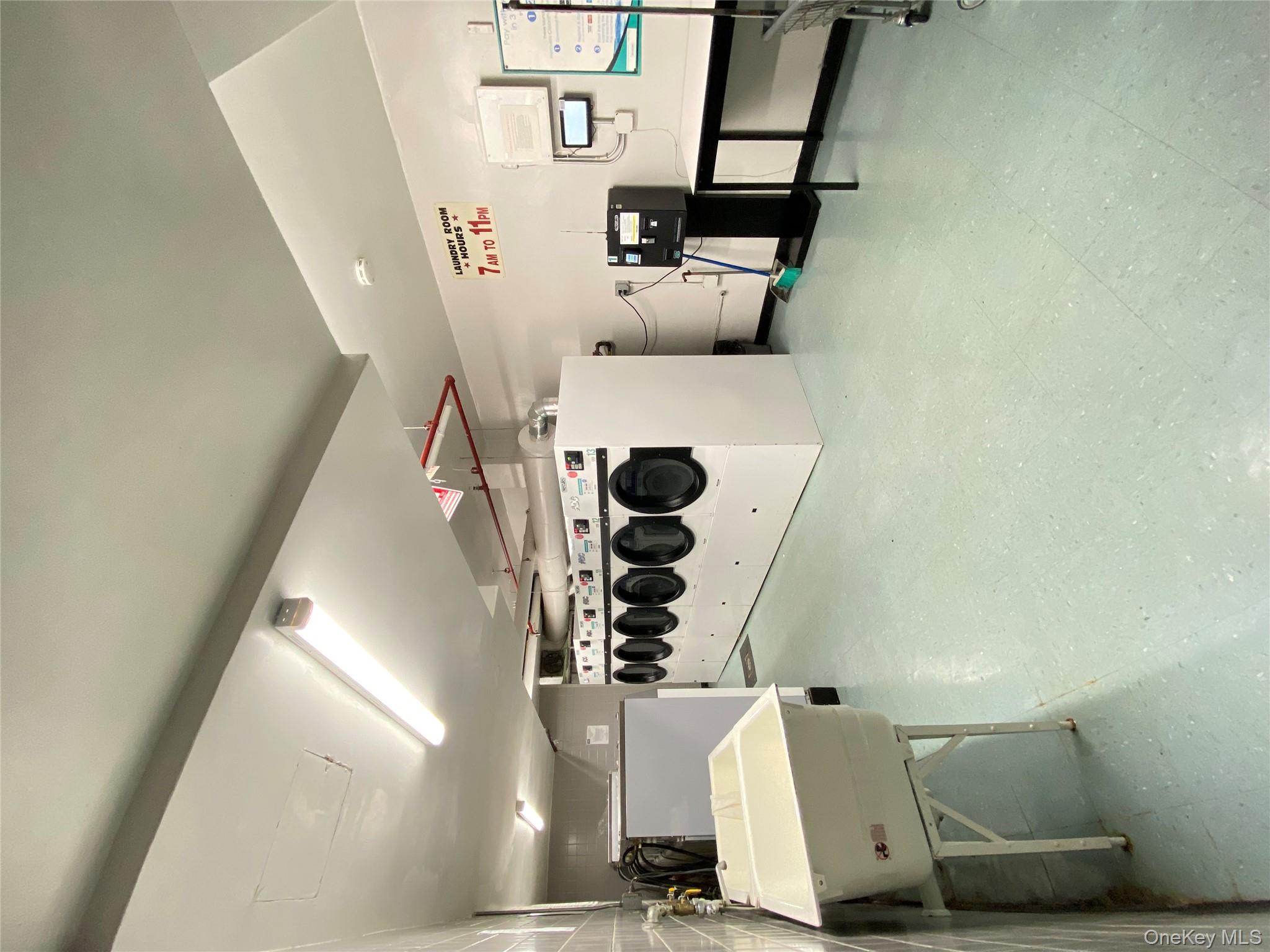 172-70 Highland Avenue, Unit 8P Queens, NY 11432 - Photo 11 of 11 a utility room with stainless steel appliances a stove a table and chairs