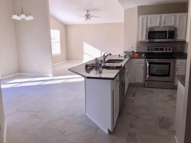 4628 Sunsail Circle Destin, FL 32541 - Photo 11 of 14 a kitchen with stainless steel appliances granite countertop a sink stove and microwave