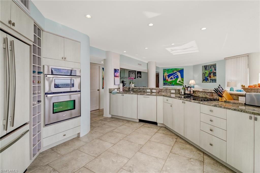 4041 Gulf Shore Boulevard North, Unit PH4 Naples, FL 34103 - Photo 18 of 35 a kitchen with stainless steel appliances a refrigerator and window