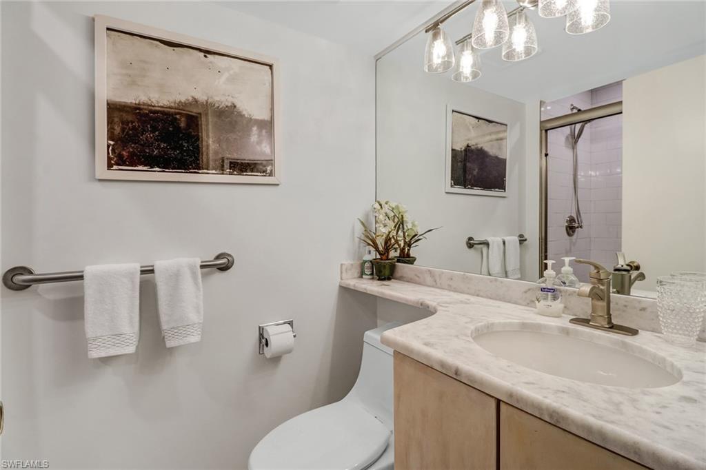 4041 Gulf Shore Boulevard North, Unit PH4 Naples, FL 34103 - Photo 22 of 35 a bathroom with a toilet sink and mirror