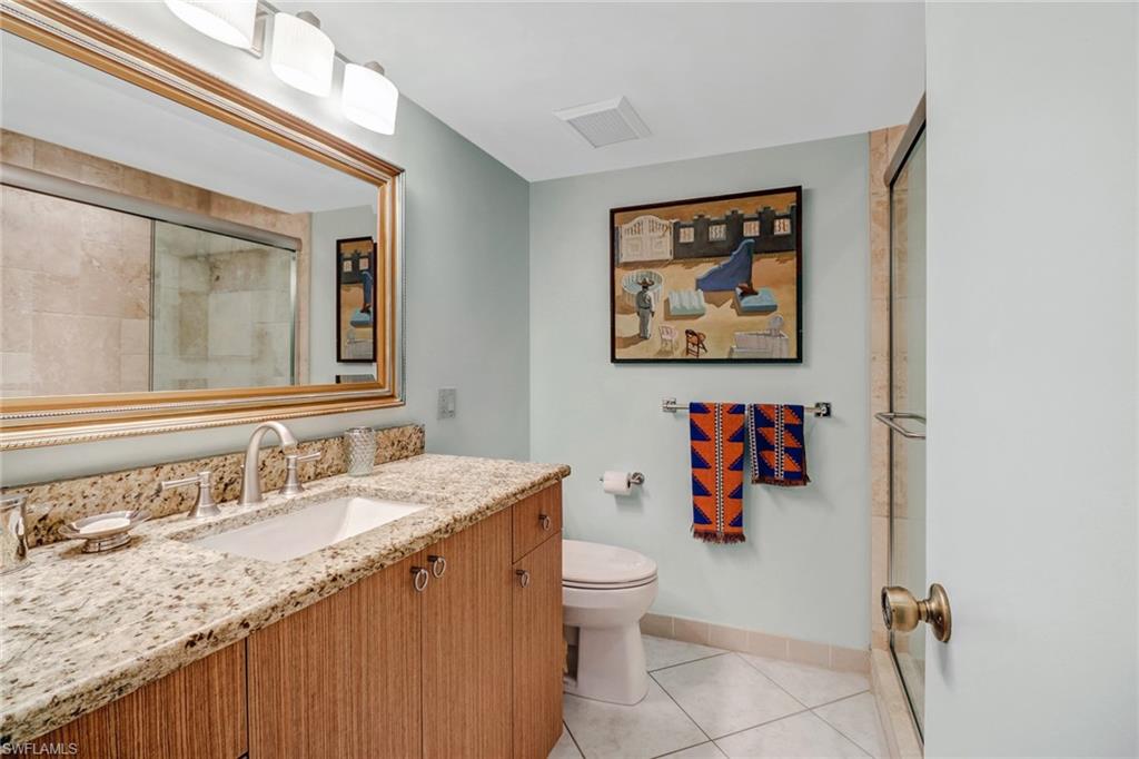 4041 Gulf Shore Boulevard North, Unit PH4 Naples, FL 34103 - Photo 24 of 35 a bathroom with a toilet sink and mirror