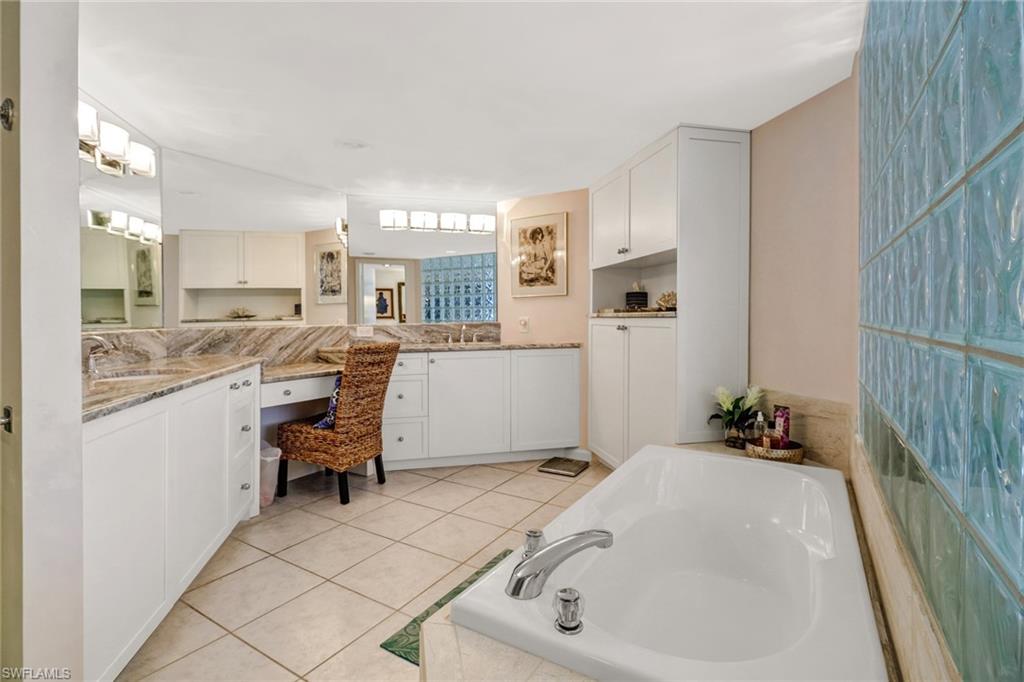 4041 Gulf Shore Boulevard North, Unit PH4 Naples, FL 34103 - Photo 28 of 35 a en suite spacious bathroom with a tub sink and mirror