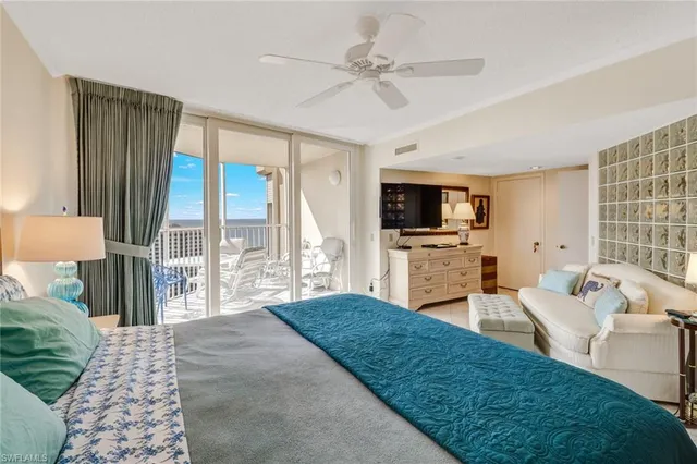 a spacious bedroom with a bed a couch and a flat tv screen