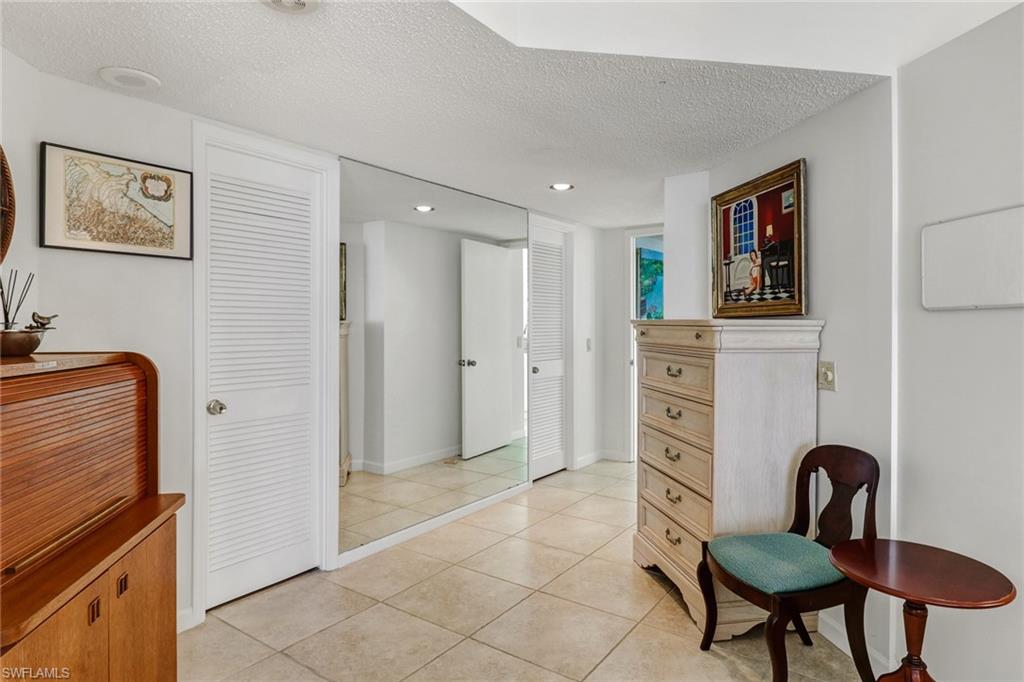 4041 Gulf Shore Boulevard North, Unit PH4 Naples, FL 34103 - Photo 31 of 35 a living room with furniture a dining table and chair