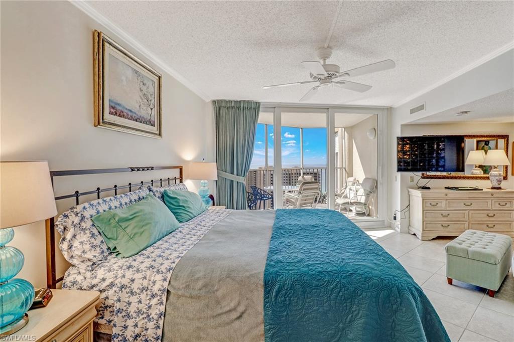 4041 Gulf Shore Boulevard North, Unit PH4 Naples, FL 34103 - Photo 33 of 35 a spacious bedroom with a bed a couch and dresser