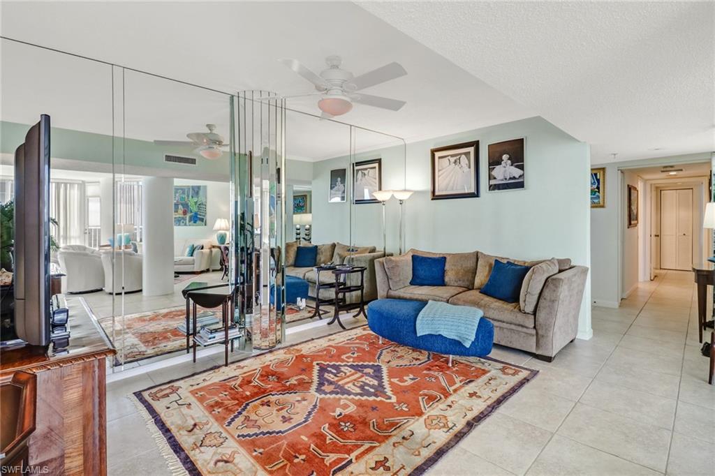 4041 Gulf Shore Boulevard North, Unit PH4 Naples, FL 34103 - Photo 9 of 35 a living room with furniture rug and a table