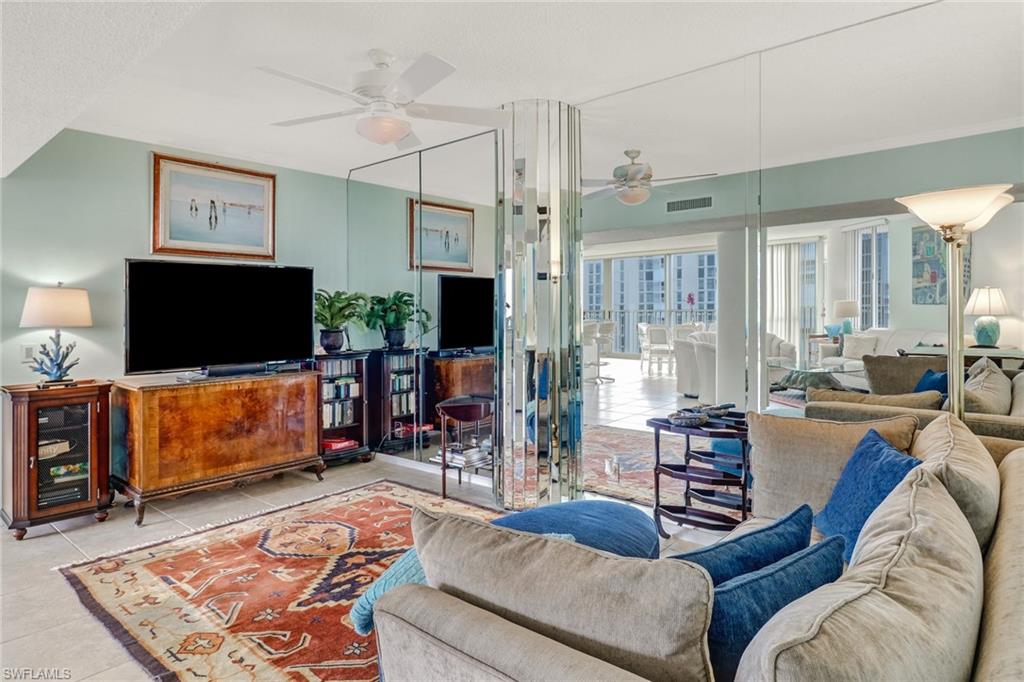 4041 Gulf Shore Boulevard North, Unit PH4 Naples, FL 34103 - Photo 10 of 35 a living room with furniture and a flat screen tv