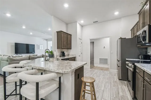 a kitchen with stainless steel appliances wooden cabinets and refrigerator