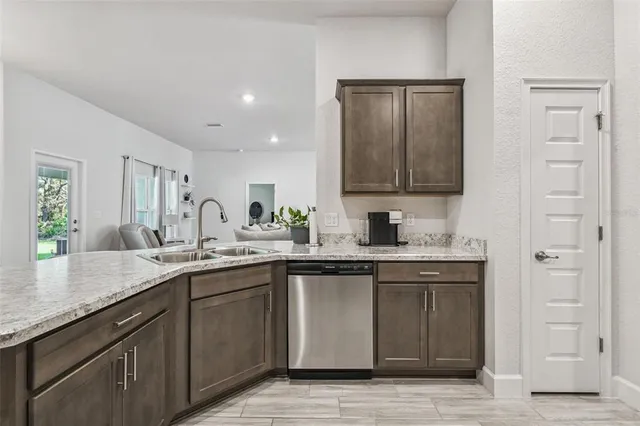 a living room with furniture a flat screen tv and kitchen view
