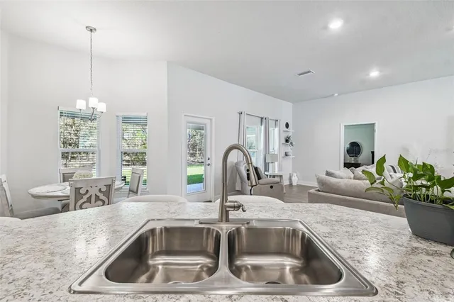 a view of a dining room with furniture a chandelier and wooden floor
