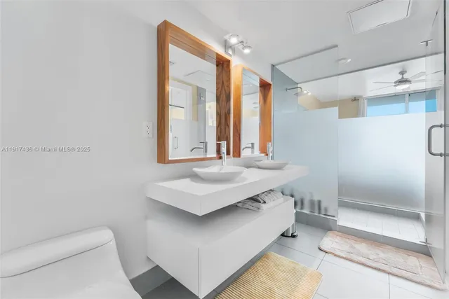 a bathroom with a sink a toilet and a large mirror