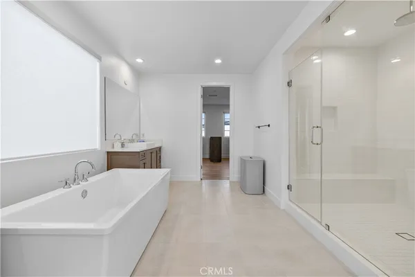a spacious bedroom with a bed and next to a window