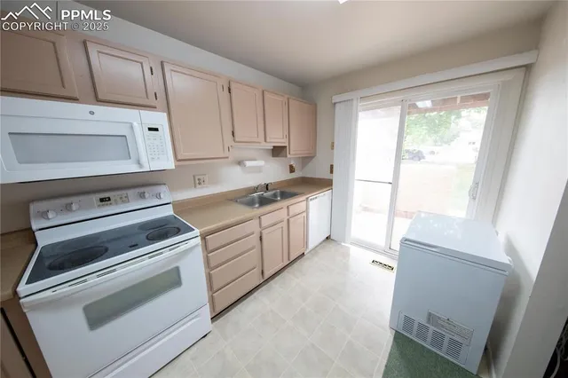 a kitchen with cabinets appliances and a window