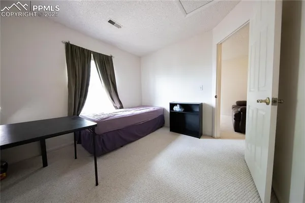a spacious bedroom with a bed and a window