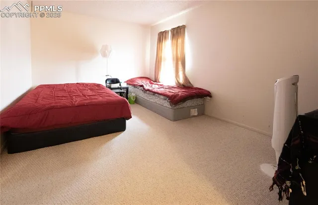 a spacious bedroom with a bed and a window