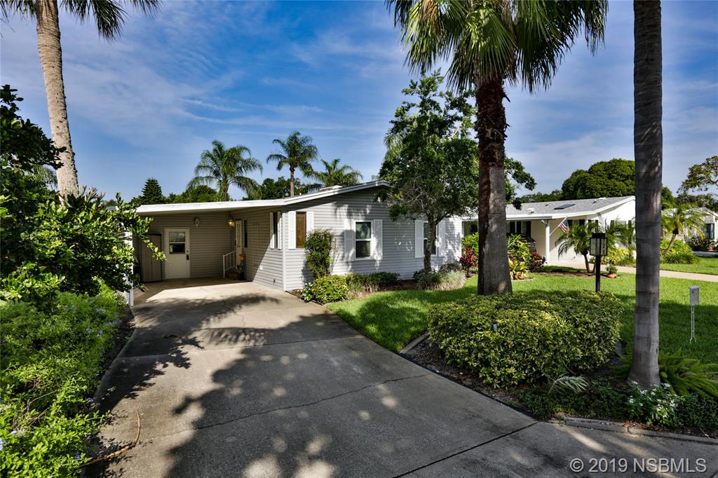 720 Navigators Way Edgewater, FL 32141 - Photo 2 of 35 a front view of a house with a garden